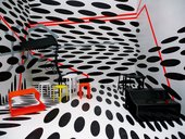 Cafeteria at the 53rd Venice Biennale designed by Tobias Rehberger 2009 photograph of an interior with floor to ceiling black and white spot pattern with minimal red yellow black and white furniture